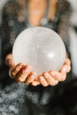 Close-up of hands holding a clear crystal ball, ideal for spiritual or metaphysical themes.